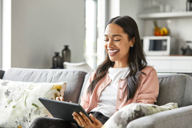 istock Smiling woman using digital tablet at home 1211322005
