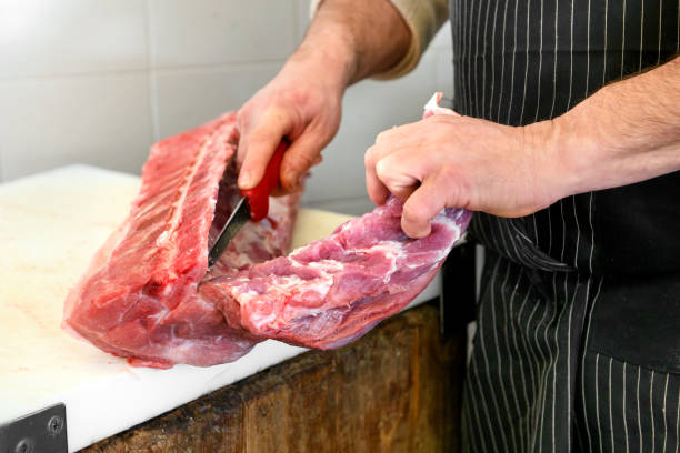 istock Butcher slicing a raw pork fillet off the bone 1211323050