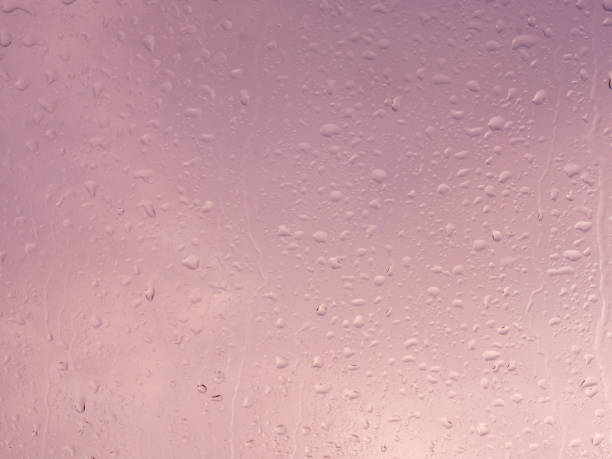 istock Wet window with rain drops and a cloudy sky outside. 1211323150