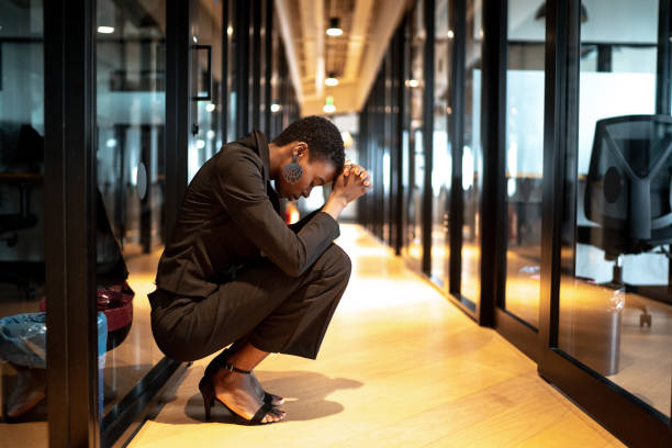 worried young businesswoman at corridor office - downsizing imagens e fotografias de stock