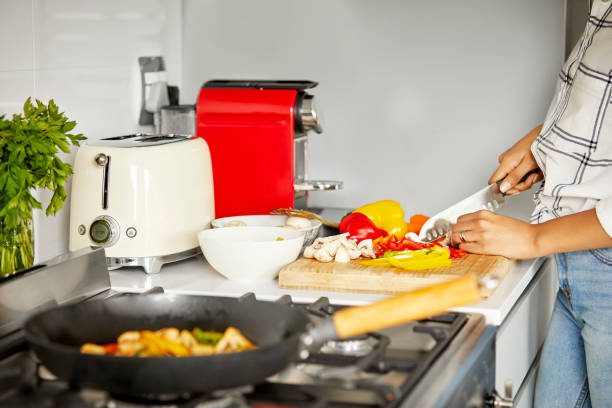 istock Woman cutting vegetables in kitchen 1211324797