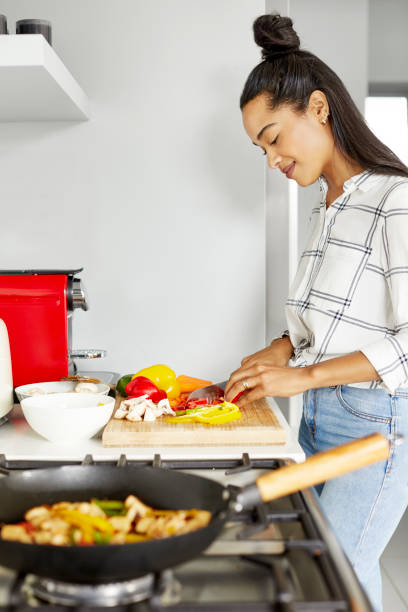 istock Female chopping vegetables at kitchen counter 1211324856