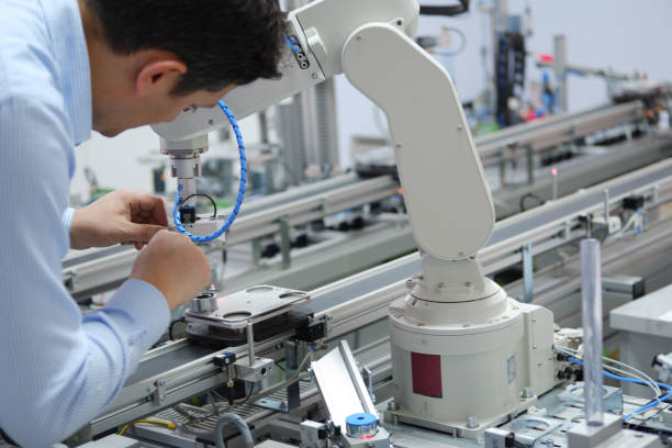 Service Engineer ( Mechanic ) repairing robot arm in a technology laboratory stock photo