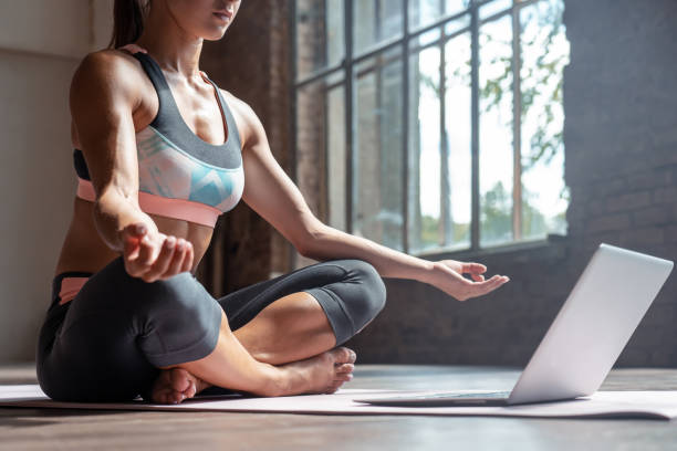 zbliżenie młodych sportowych pasuje szczupła kobieta trener ćwiczyć wideo online szkolenia hatha instruktor jogi nowoczesny laptop medytować postawa sukhasana relaks oddychać łatwe siedzenie stanowią siłownia zdrowego stylu życia koncepcji - yoga class instructor yoga exercising zdjęcia i obrazy z banku zdjęć