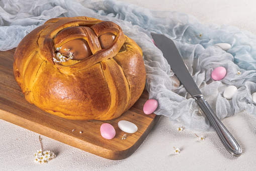 Portuguese traditional Easter cake. Folar with eggs on wooden table