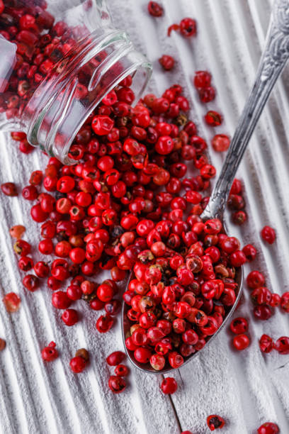 istock pink peppercorns on white wooden rustic background 1211333251