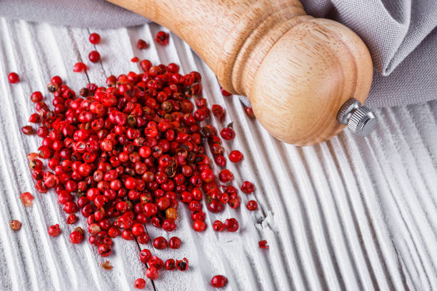istock pink peppercorns on white wooden rustic background 1211333528
