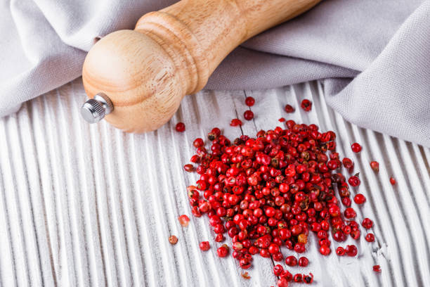 istock pink peppercorns on white wooden rustic background 1211333652