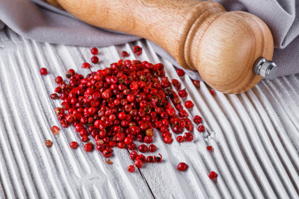 istock pink peppercorns on white wooden rustic background 1211333689