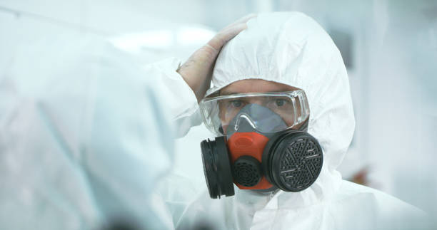 istock Two people in lab wearing protective suits are talking 1211333785