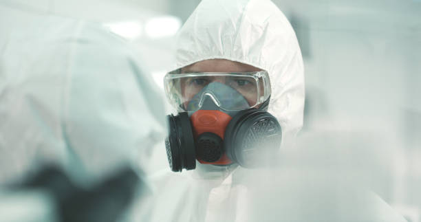 istock Two people in lab wearing protective suits are talking 1211333829