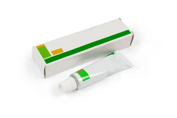Tube pack of healing ointment and his cardboard box on a white background