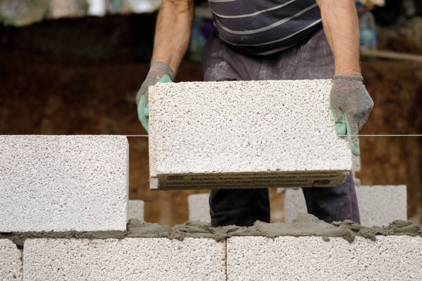 Close-up of construction worker builds brick wall stock photo