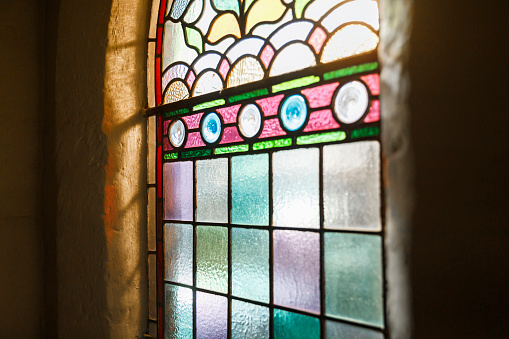 An antique chapel window, shining with colour from the sun.