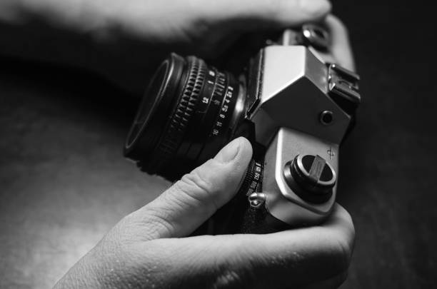 istock Hands holding a metal camera with a lens. 1211337062