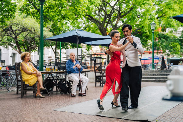 Seniors watching expert young couple dance the tango Hispanic seniors in 70s and 80s enjoying beers and expert tango dancing on spring day in Plaza Dorrego. plaza dorrego stock pictures, royalty-free photos & images
