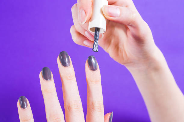 istock Woman applying nail polish 1211338244