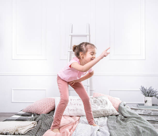 istock Cute little girl playing on the bed. 1211339715