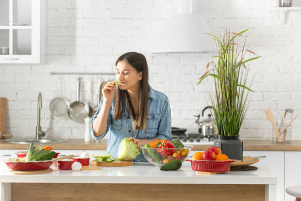 istock A young woman is preparing a salad in the kitchen . 1211339948