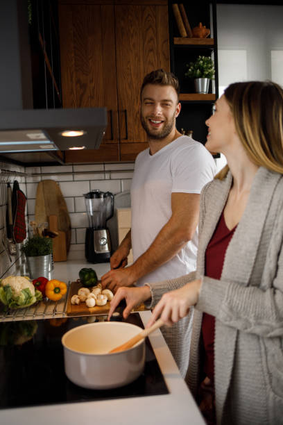 istock Young romantic couple cooking in the kitchen together 1211341491