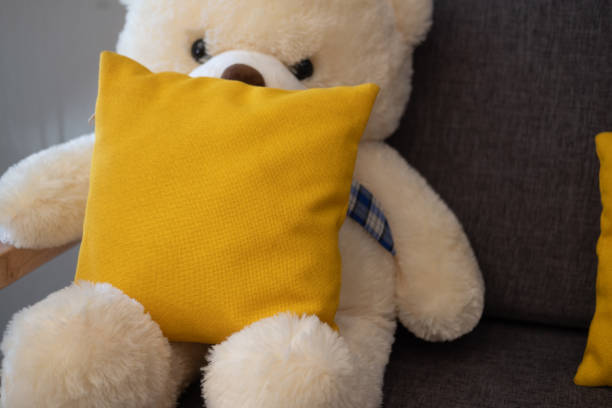 istock Yellow pillow and teddy bear on sofa in living room 1211342869