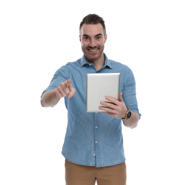 istock Happy casual man holding tablet, smiling and pointing 1211343393