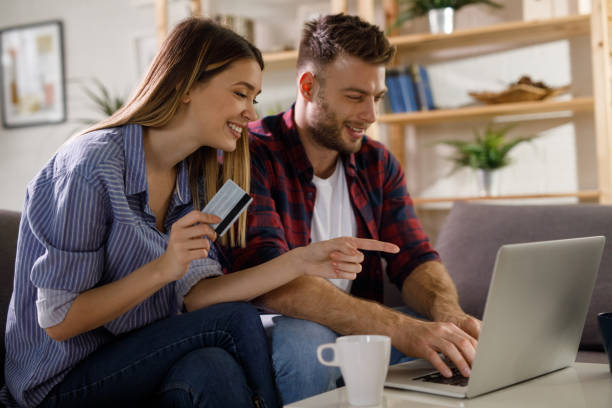 istock Young affectionate couple shopping online using laptop 1211344496