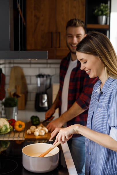 istock Young romantic couple cooking in the kitchen together 1211344762