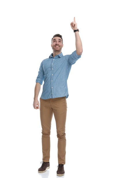 istock Smiling casual man pointing up while wearing blue shirt 1211345314