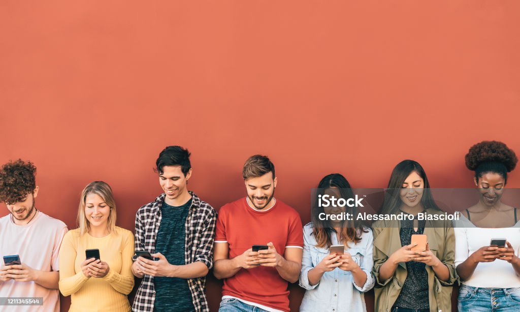 Group young people using mobile smartphone outdoor - Millennial generation having fun with new trends social media apps - Youth technology addicted - Red background Social Media Stock Photo