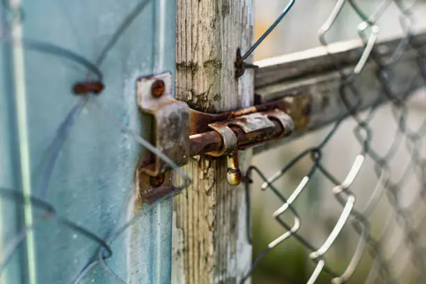 Old vintage door handles. Rusty metal locks and latches. Protective devices for wooden yard gates