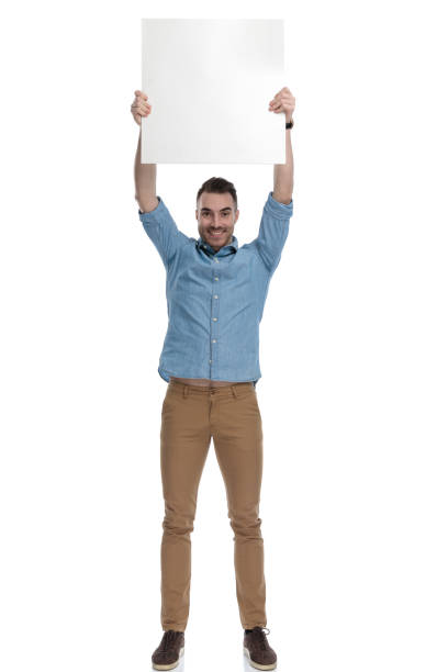istock Cheerful casual man holding blank billboard above his head 1211346432