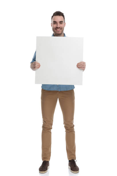 istock Happy casual man smiling and holding a blank billboard 1211346468