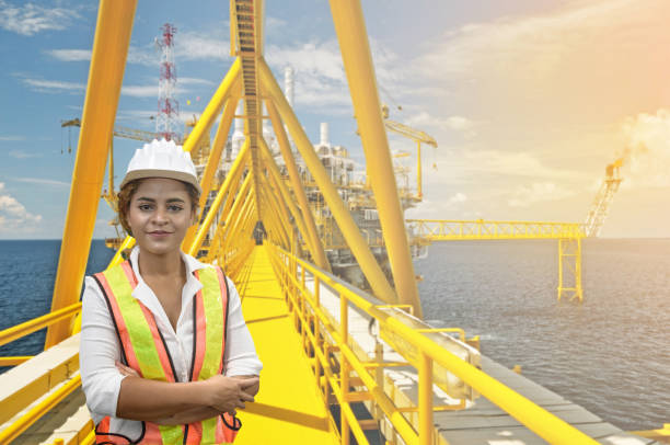 istock mixed race woman engineer staff worker and offshore rig background concept. 1211346522