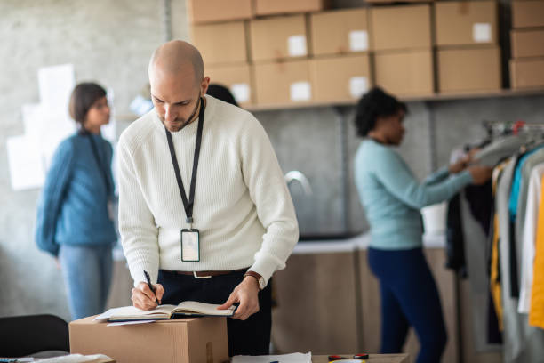 istock Entrepreneur standing and writing down new orders at online shop office 1211346640