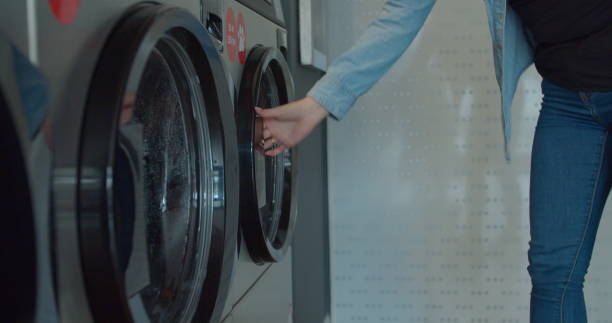 istock Woman take away laundry clothes. Self-service public laundry. 1211346846