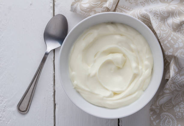 istock Yogurt bowl with natual creamy white Greek yoghurt on white rustic table close up 1211348840