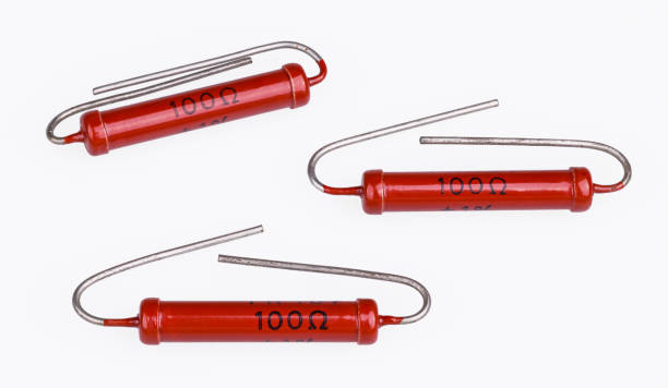 istock Three cylindrical carbon power resistors with bent lead wires on white background 1211350078