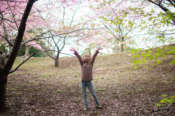 istock Cute girl with cherry blossoms 1211350308