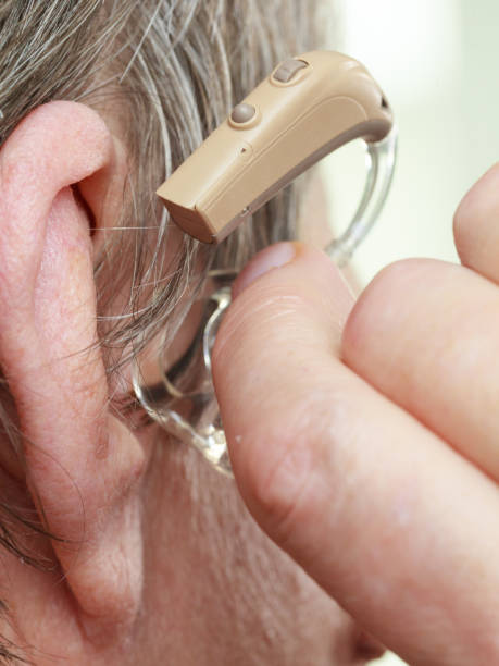 istock Closeup senior woman using hearing aid 1211350350