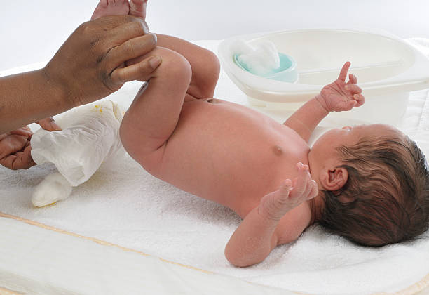 Mid-adult woman getting her baby boy dressed in the nursing room.