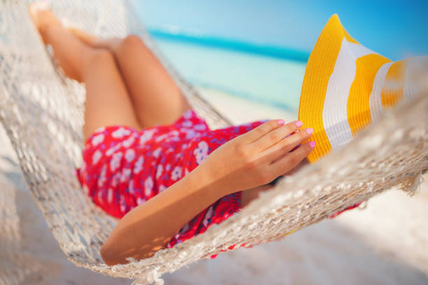 istock Young girl resting in a hammock under tall palm trees, tropical beach 1211352281
