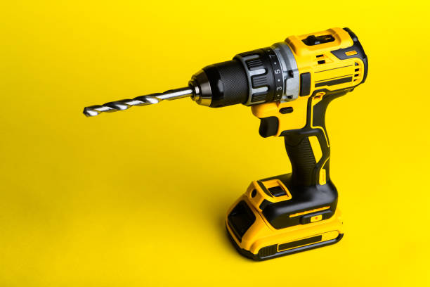 istock cordless drill and a drill on a yellow background 1211352441
