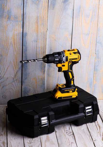 istock cordless drill and a drill on a wooden background 1211352454