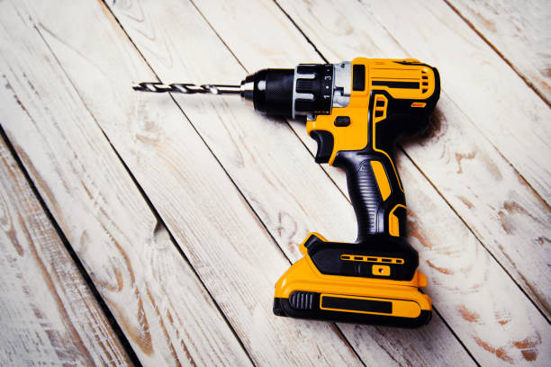 istock cordless drill and a drill on a wooden background 1211352467