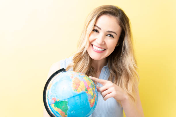 istock Happy Woman Is Pointing At World Map 1211353491