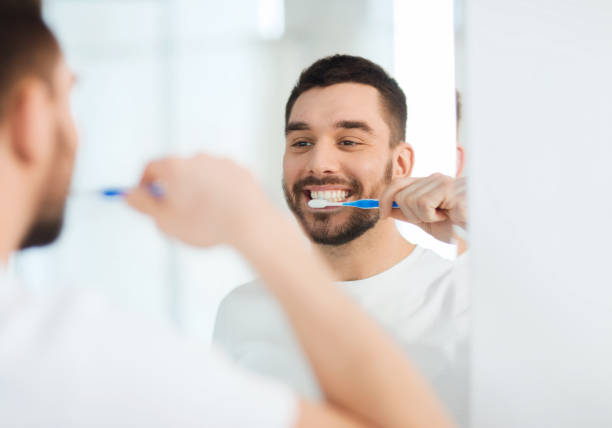 istock man with toothbrush cleaning teeth at bathroom 1211355124
