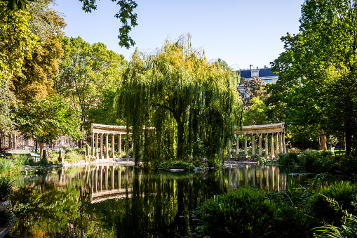 Corinthian colonnade and pond in Parc Monceau gardens, Paris, France