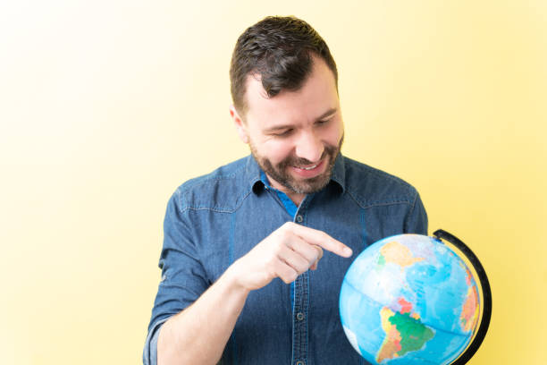 istock Happy Man Is Pointing At World Map 1211355863