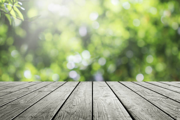istock Wooden table and blurred fresh garden nature bokeh background. 1211356270